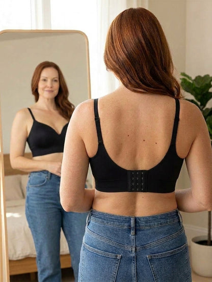 Back view of the black bra in a mirror: wide back panel and flat band