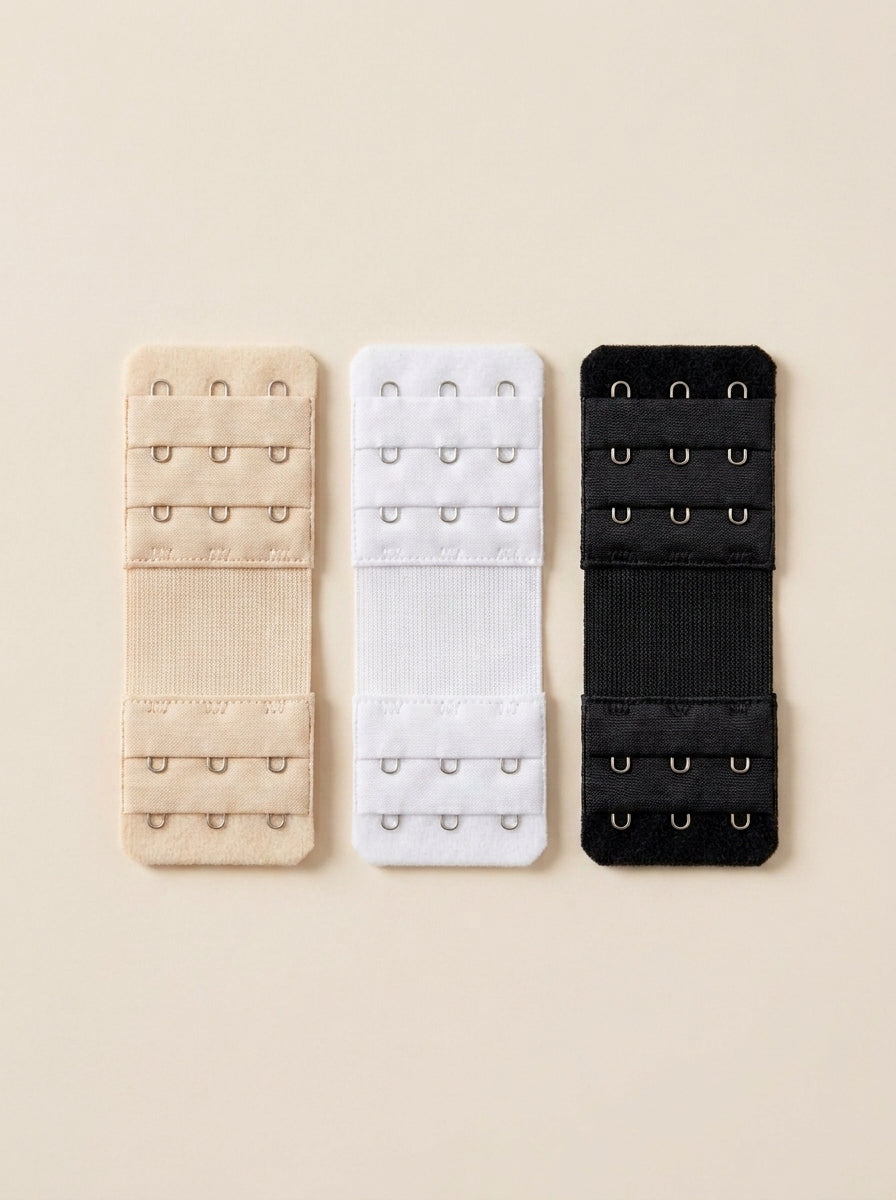 Three Snug bra extenders in black, white and cream, laid flat