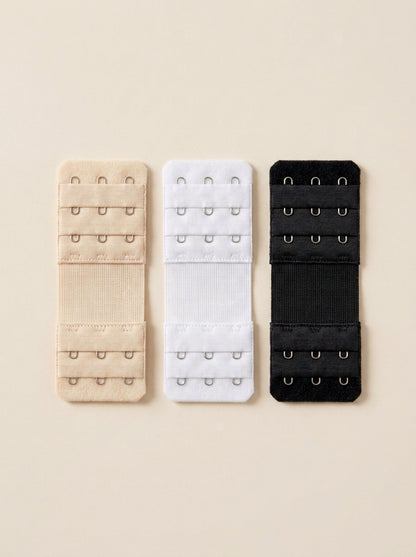 Three Snug bra extenders in black, white and cream, laid flat