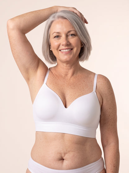 Diane, 38DD, in the Snug Wireless Shaping Bra in White — front view, one hand on her head